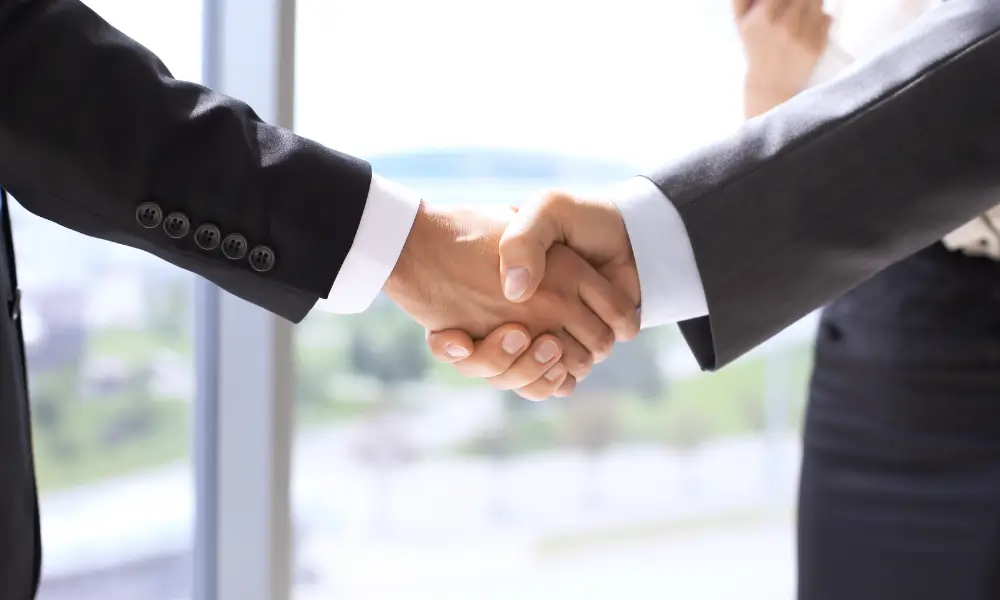 Investidor negociando investimentos com gerente de banco com segurança.