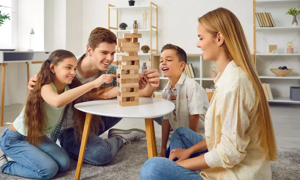 Família jogando jogo de tabuleiro financeiro para ensinar dinheiro brincando.