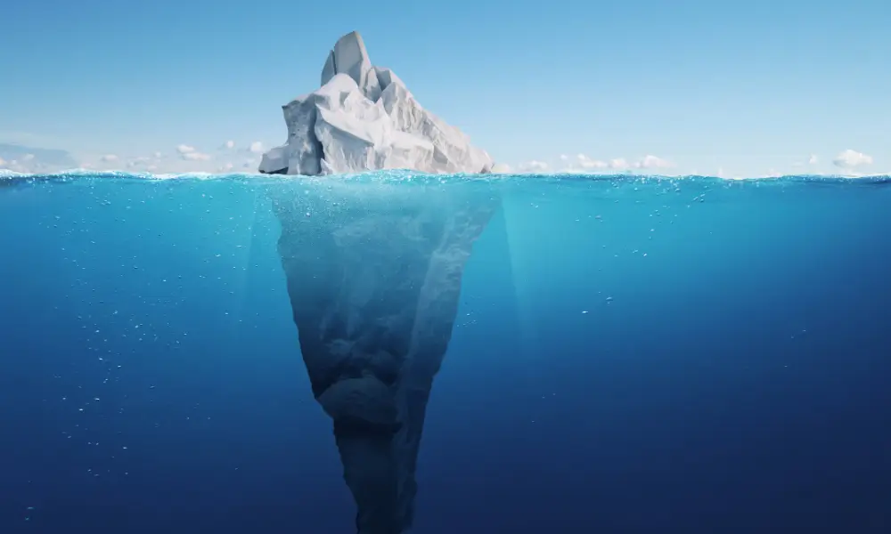 Ilustração de iceberg mostrando os juros abusivos escondidos na dívida do cartão.